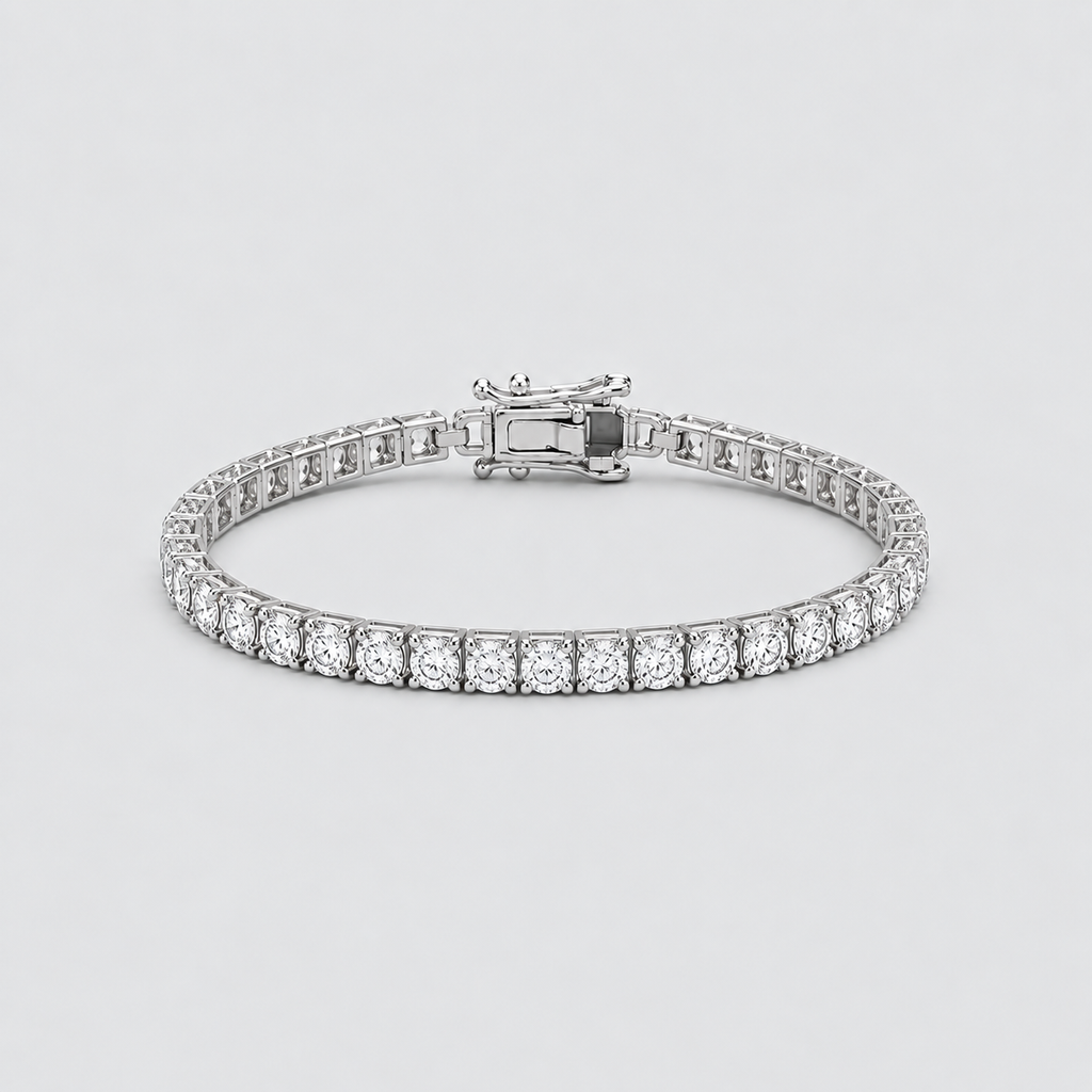 A silver tennis bracelet with a continuous row of round-cut clear stones and a clasp closure, shown on a light gray background.