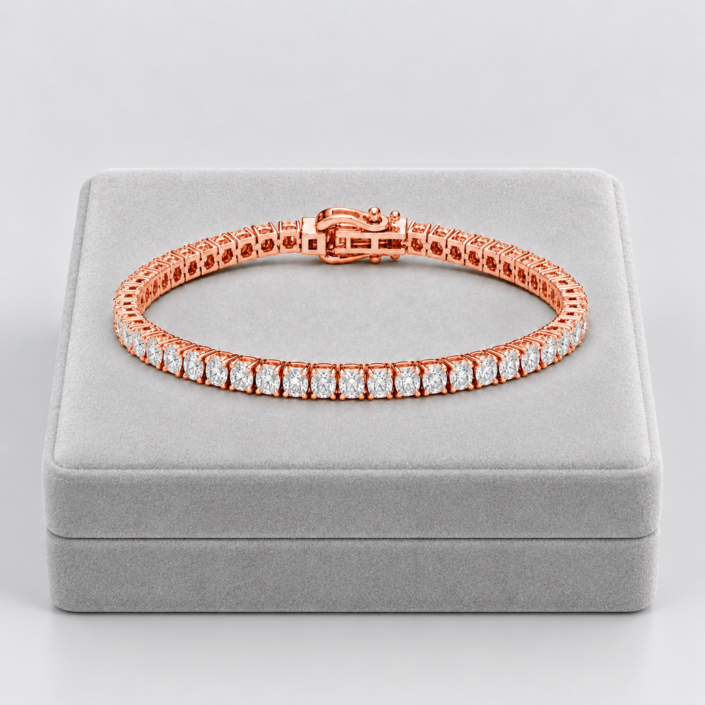 A rose gold tennis bracelet with a row of clear stones, displayed on a gray jewelry box against a light gray background.