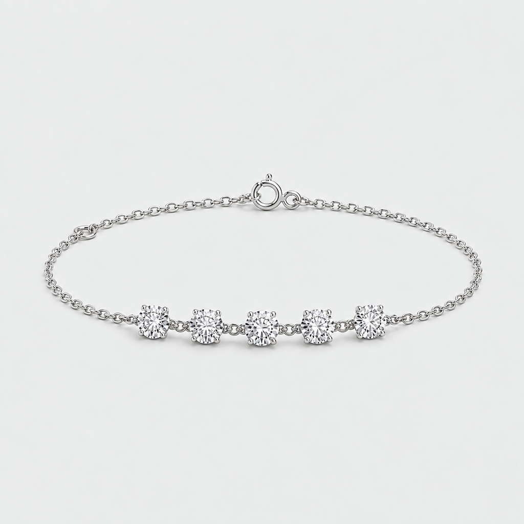 A delicate silver chain bracelet featuring five round-cut clear gemstones set in a row, displayed on a clean light gray background.