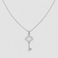 A silver key-shaped pendant necklace adorned with small clear stones, suspended from a delicate silver chain against a light gray background.