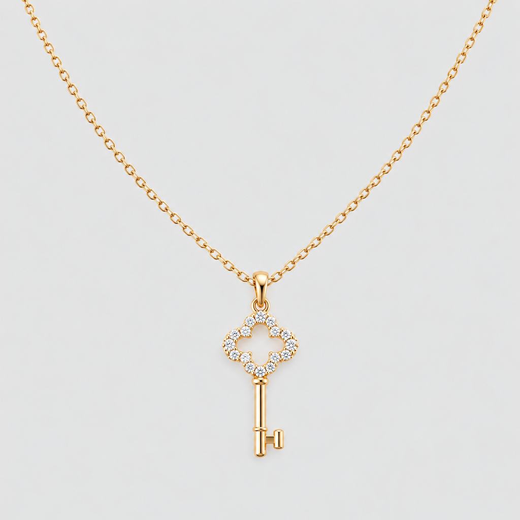 A gold key pendant necklace with a diamond-encrusted key head, displayed on a clean light gray background.