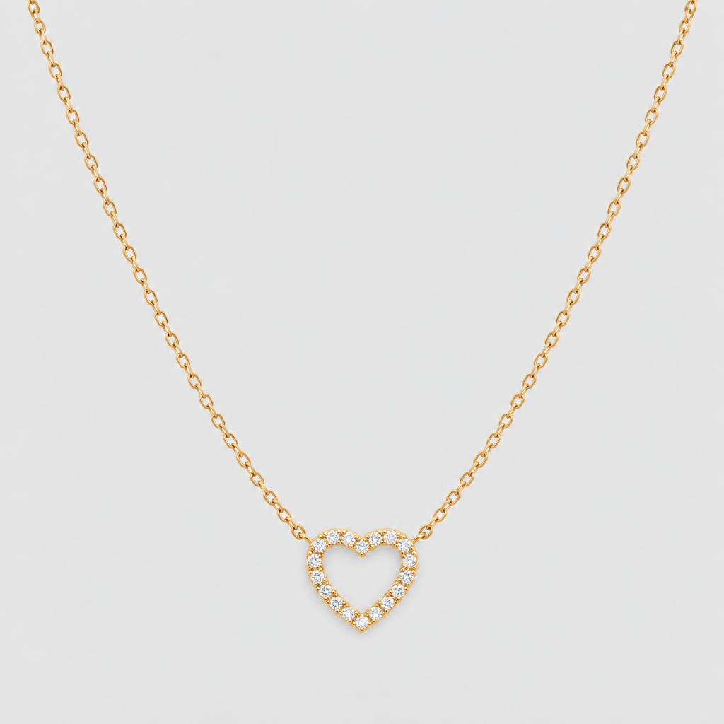A delicate gold chain necklace featuring an open heart pendant encrusted with small clear stones, displayed against a clean, light gray background.