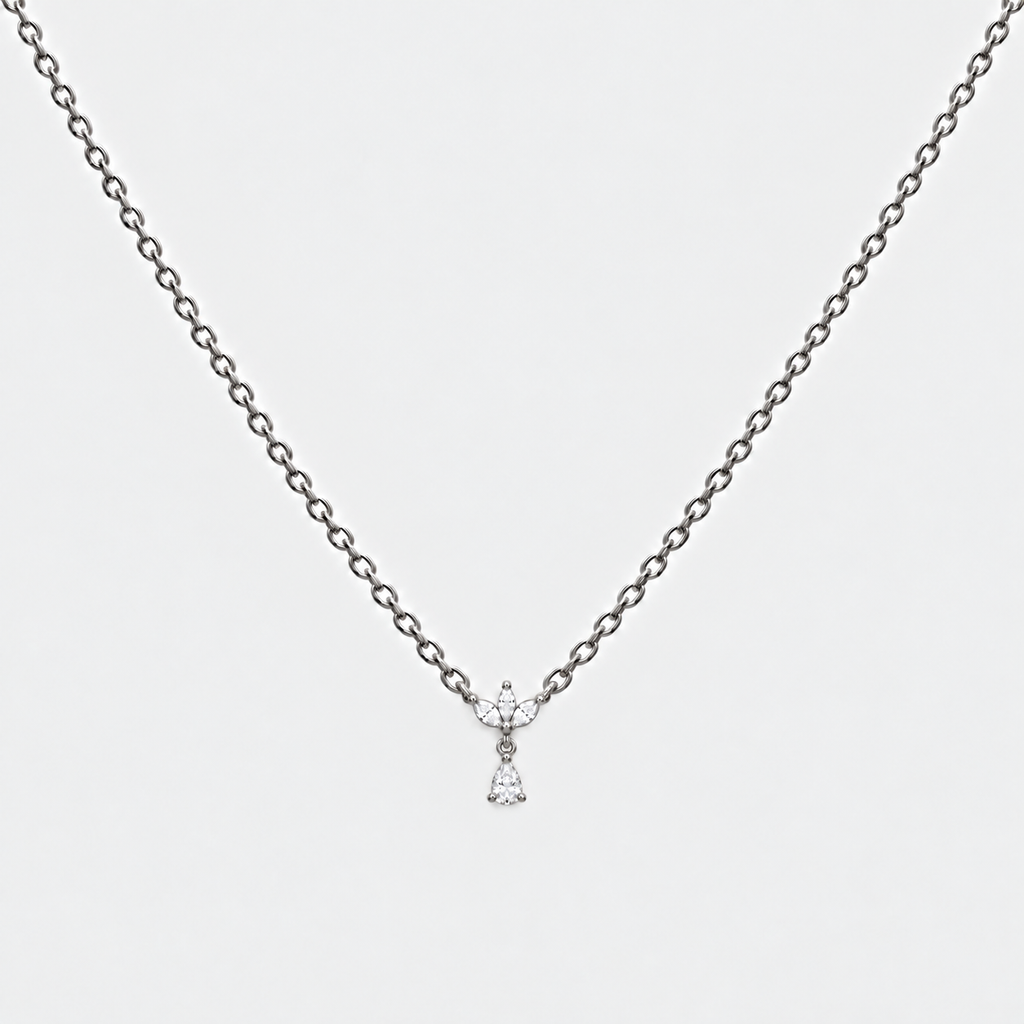 A delicate silver chain necklace with a small bow-shaped pendant set with clear gemstones, displayed against a light gray background.