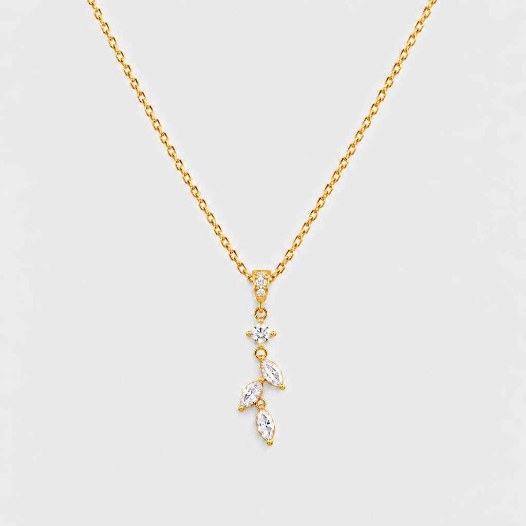 A gold chain necklace with a delicate pendant featuring a small star and three marquise-cut clear stones set in gold, displayed against a light gray background.