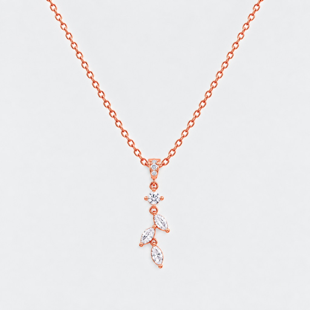 A rose gold necklace with a delicate leaf-shaped pendant set with clear marquise and round gemstones, displayed on a light gray background.