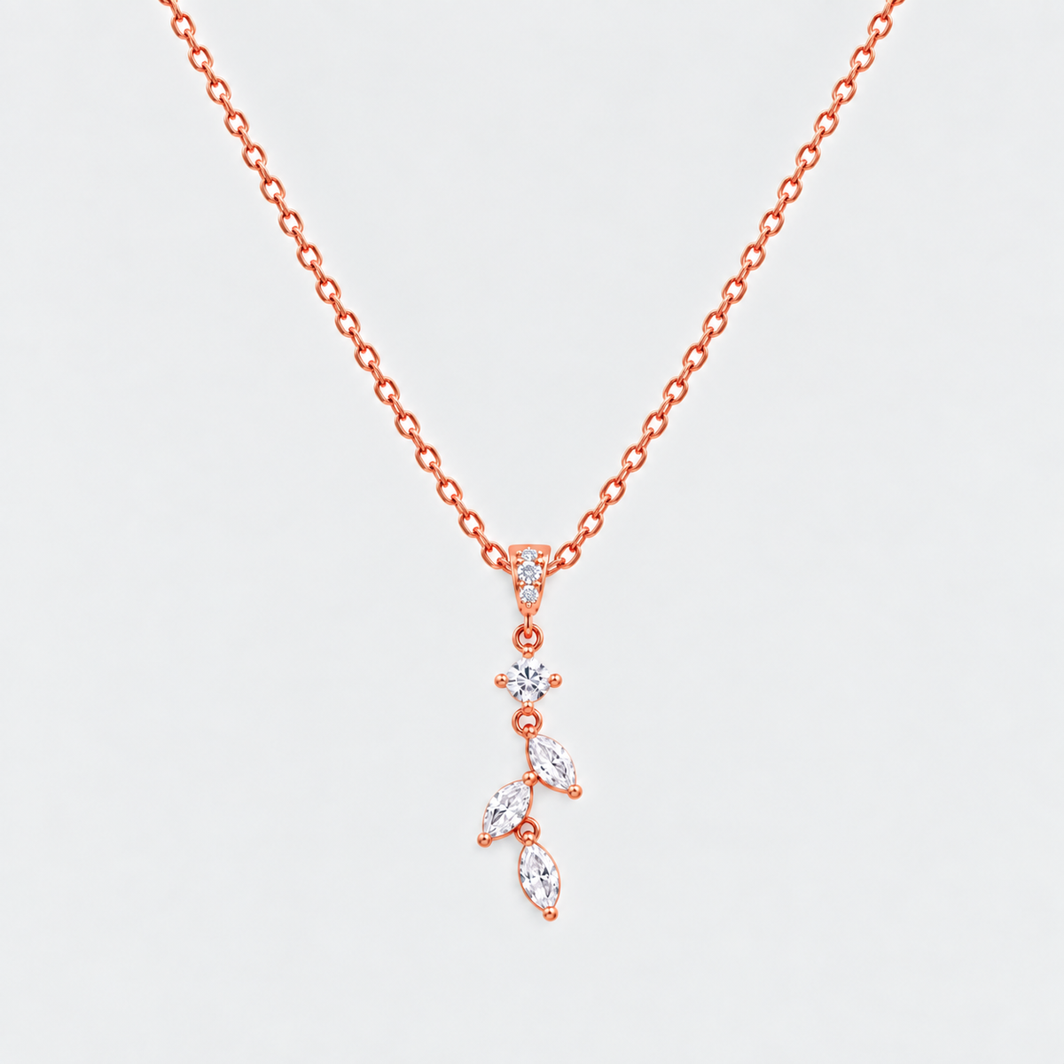 A rose gold necklace with a delicate leaf-shaped pendant set with clear marquise and round gemstones, displayed on a light gray background.