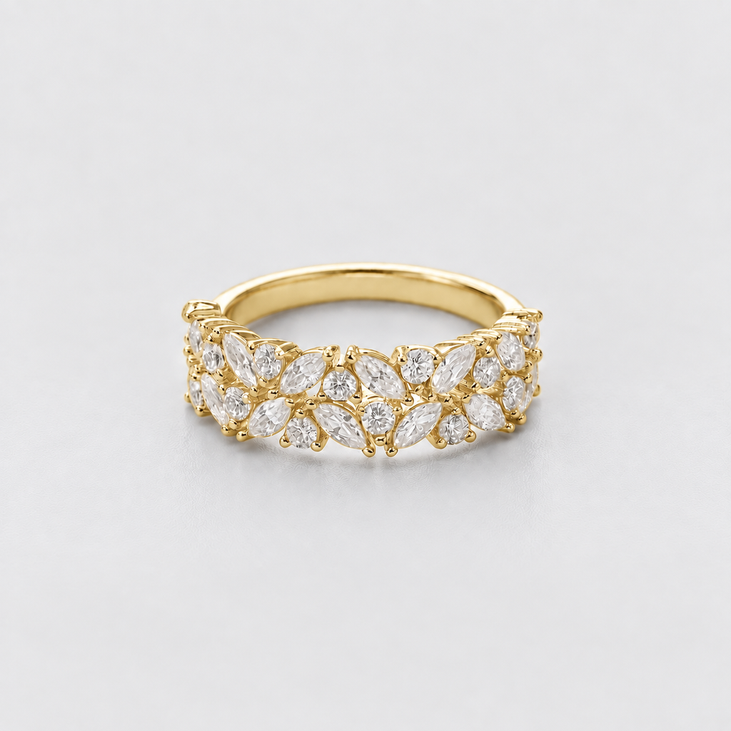 A yellow gold ring featuring a double row of marquise-cut clear gemstones in a floral cluster setting, photographed on a clean light gray background.