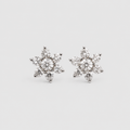 A pair of snowflake-shaped stud earrings made of silver metal and clear gemstones, set against a plain light gray background.