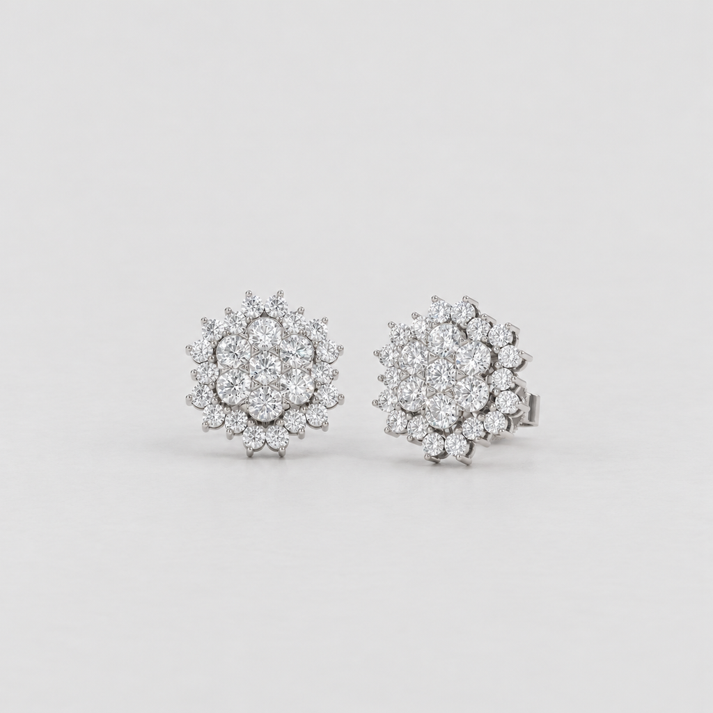 A pair of round cluster stud earrings set with clear gemstones in a silver-toned metal, displayed on a clean light gray background.