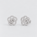 A pair of silver-toned interlocking flower stud earrings paved with small clear stones, shown on a light gray background.