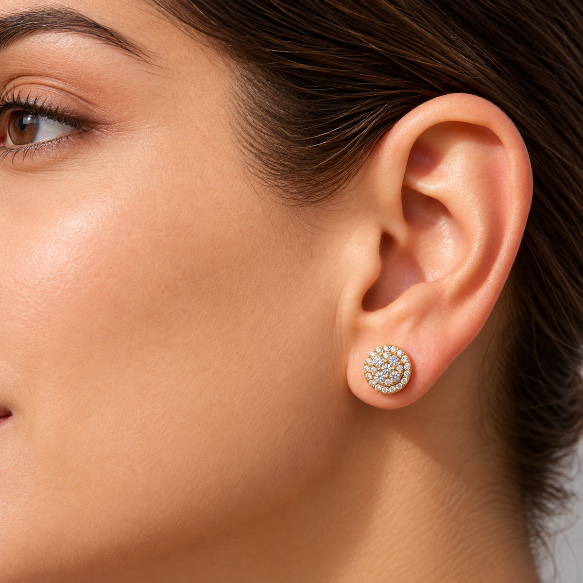 Woman wearing round cluster diamond stud earrings in rose gold