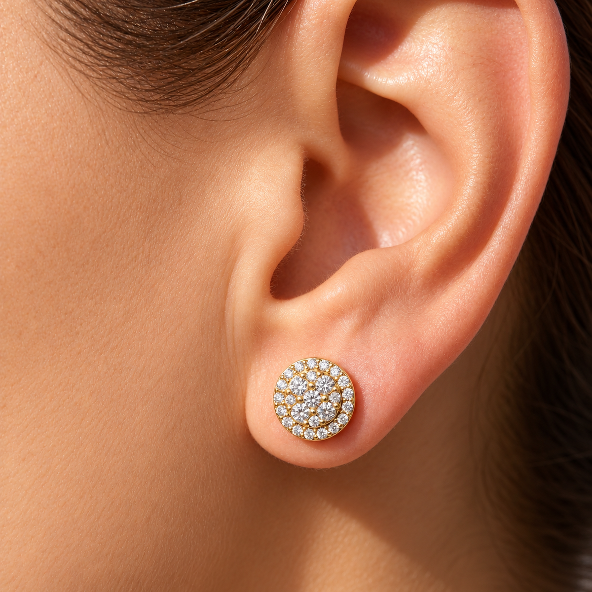 Round diamond cluster stud earring in yellow gold on woman's ear