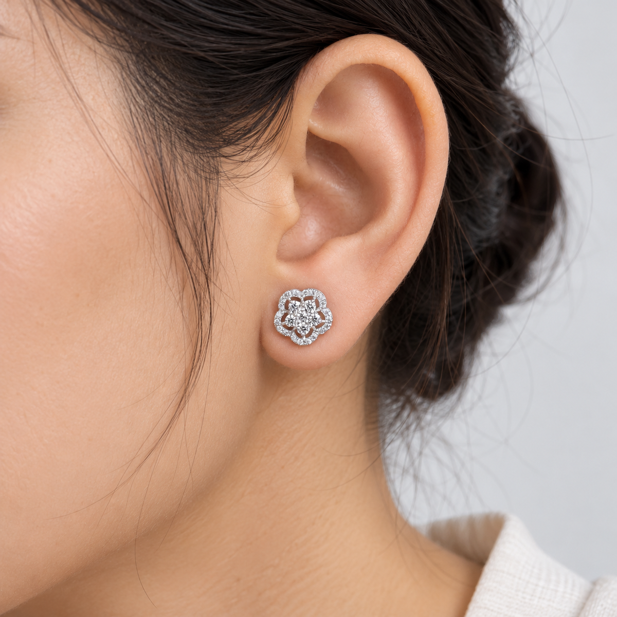 Cluster diamond flower stud earring on a woman's ear