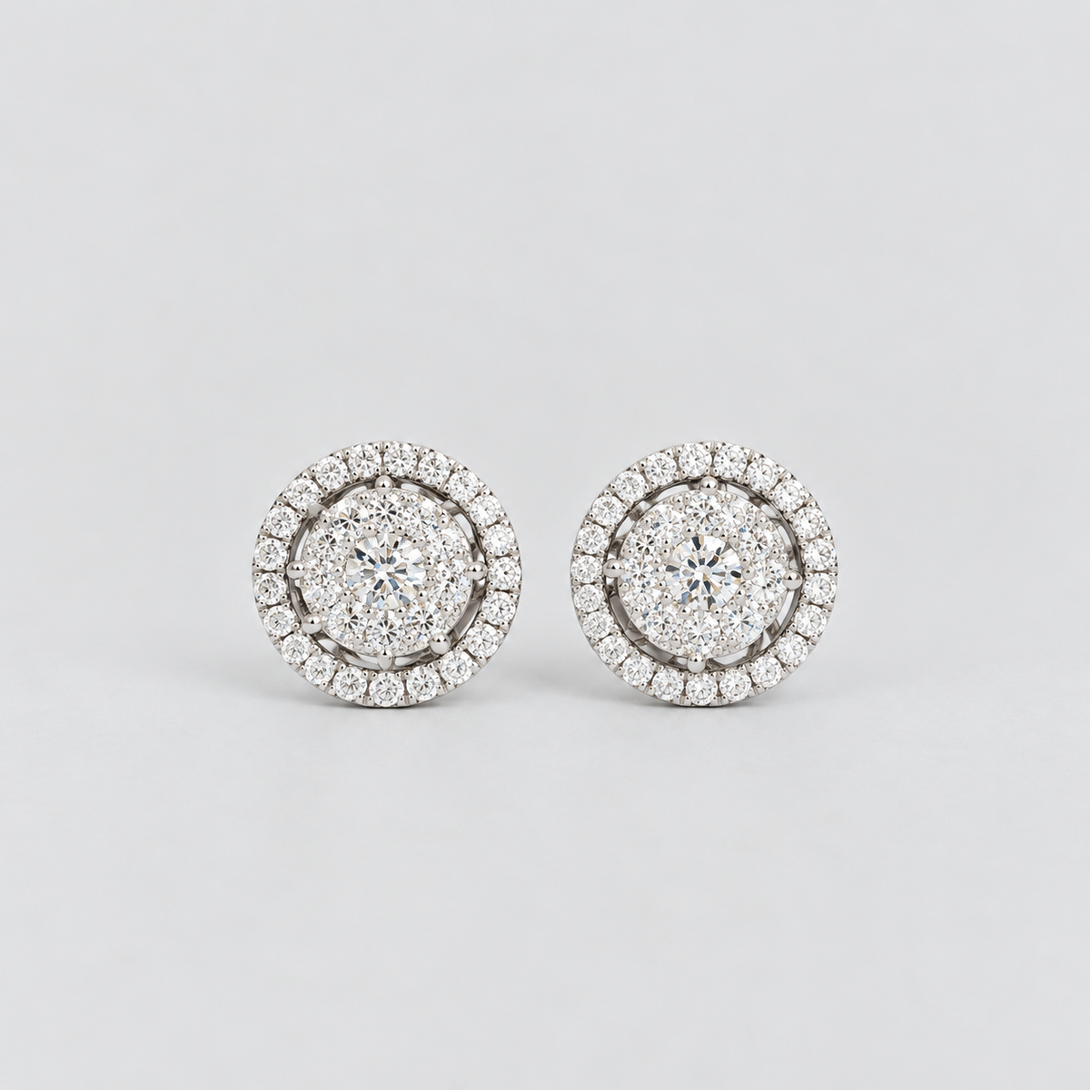 Round cluster diamond stud earrings in white gold with a halo border