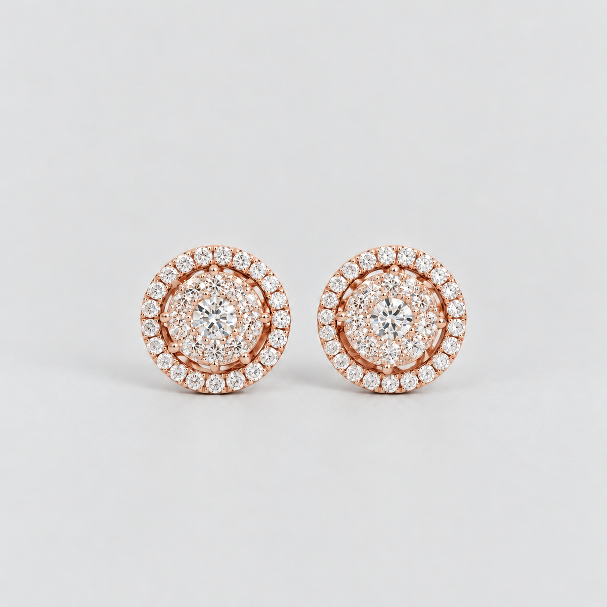 Round cluster diamond stud earrings in rose gold with a halo border