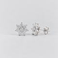 A pair of flower-shaped cluster diamond stud earrings in a white gold setting.
