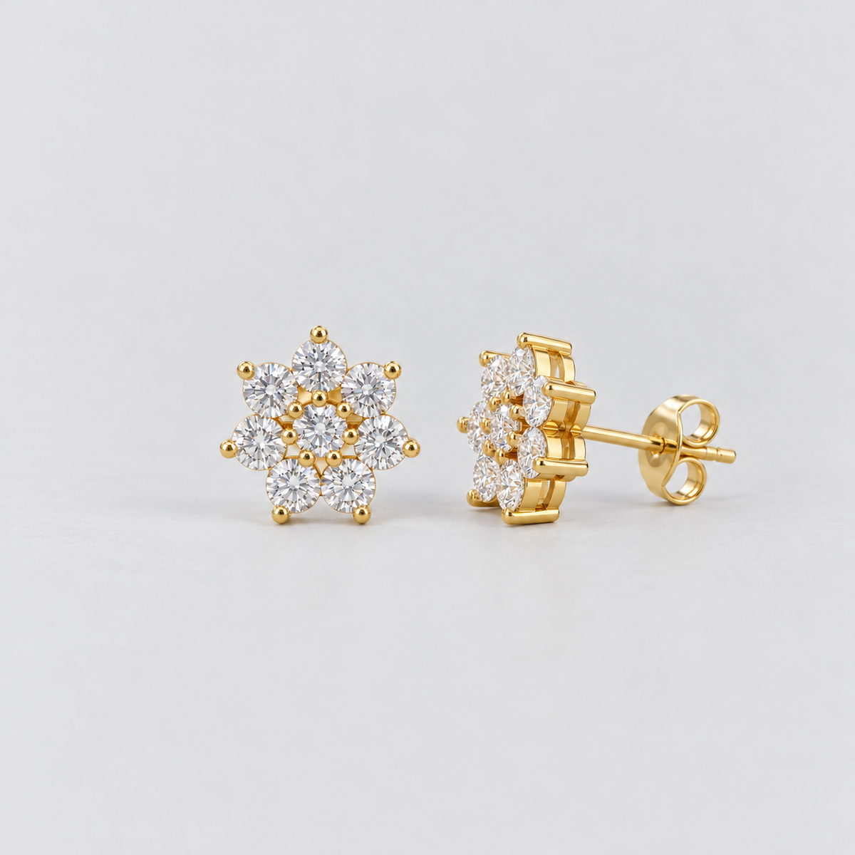 A pair of flower-shaped cluster diamond stud earrings in a yellow gold setting.
