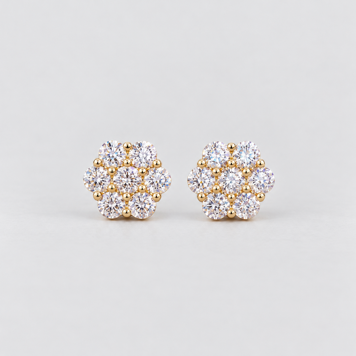 A pair of women's diamond cluster stud earrings in a hexagonal floral pattern in yellow gold metal.
