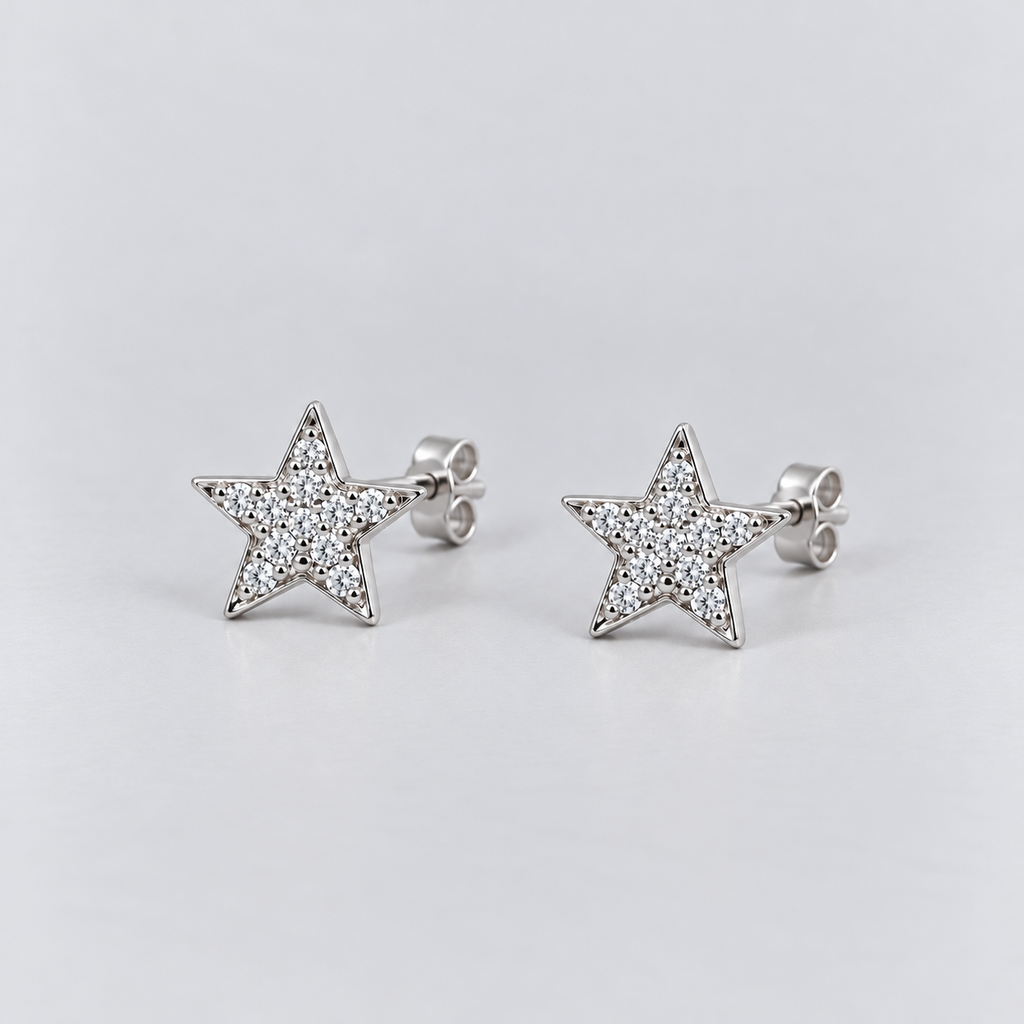 A pair of silver star-shaped stud earrings paved with small clear stones, shown on a light gray background.