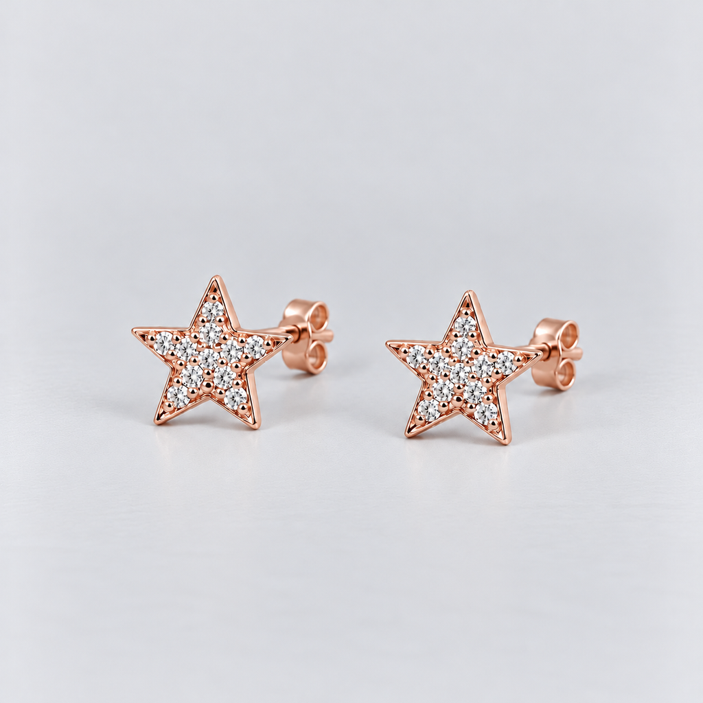 A pair of rose gold star-shaped stud earrings paved with small clear stones, displayed on a light gray background.