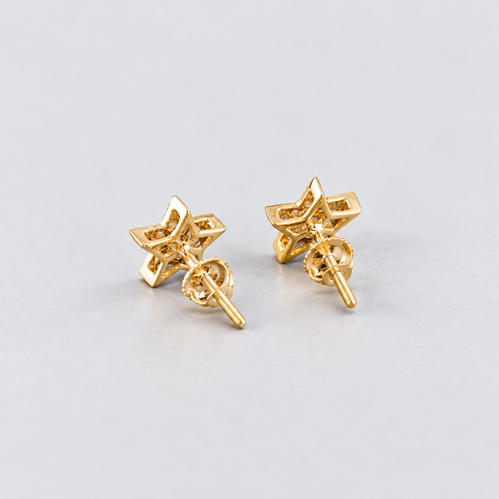 A pair of gold star-shaped stud earrings with butterfly backings, shown on a light gray background.