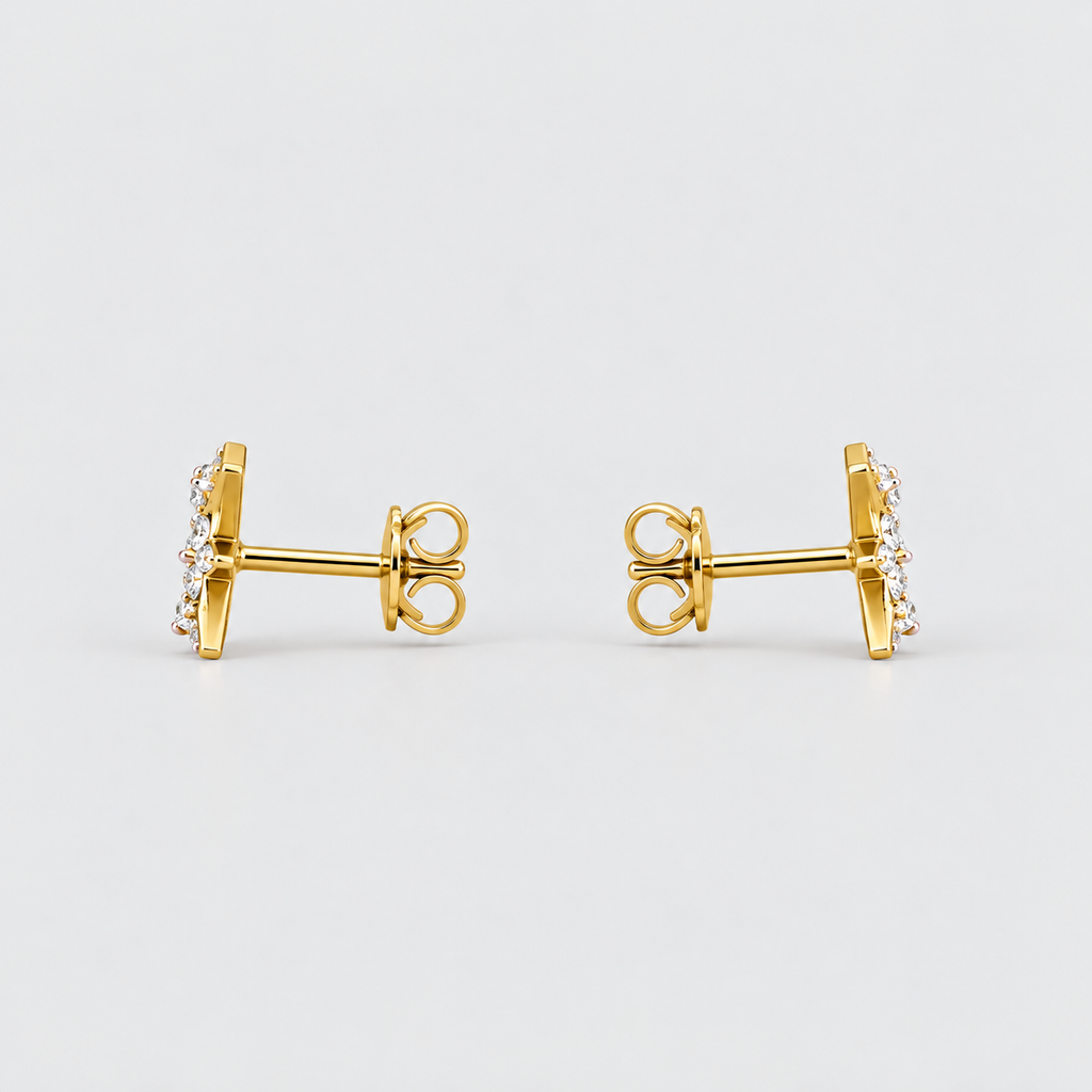 A pair of gold post earrings with a small cluster of clear stones on the front, shown from the side against a light gray background.