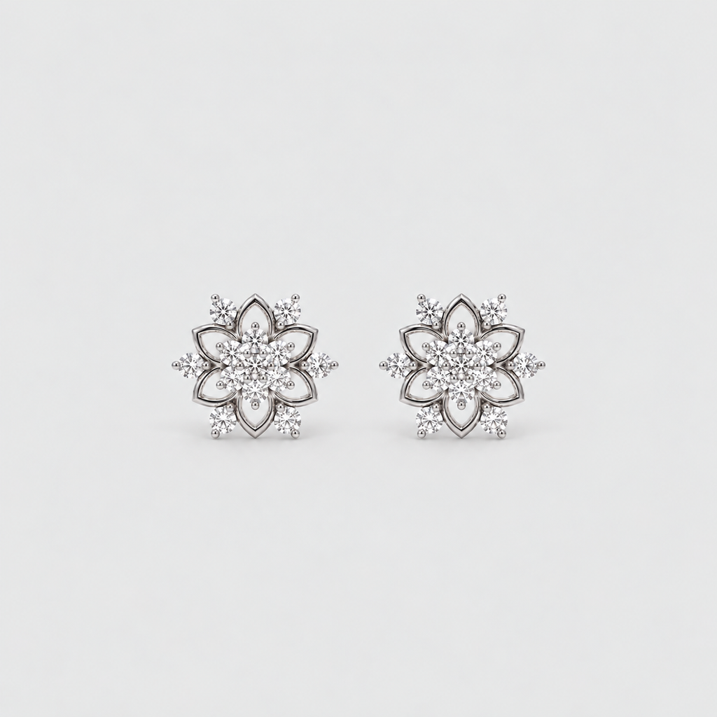 A pair of silver-toned flower-shaped stud earrings set with clear gemstones, displayed on a clean, light gray background.
