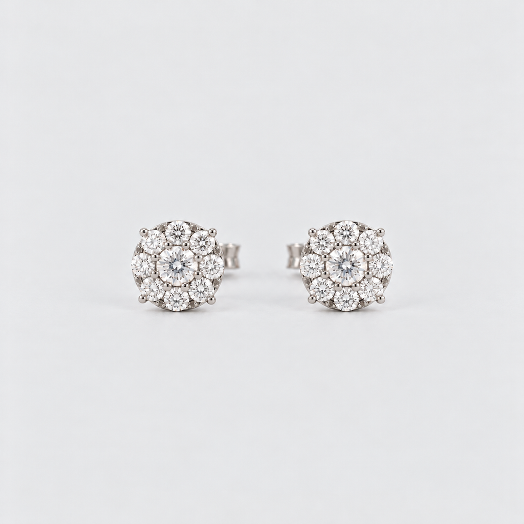 A pair of round cluster stud earrings featuring a central clear gemstone surrounded by multiple smaller clear stones in a silver-toned setting, photographed on a clean light gray background.