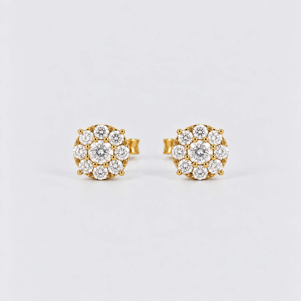 A pair of gold stud earrings with round floral clusters of clear gemstones, photographed on a clean light gray background.