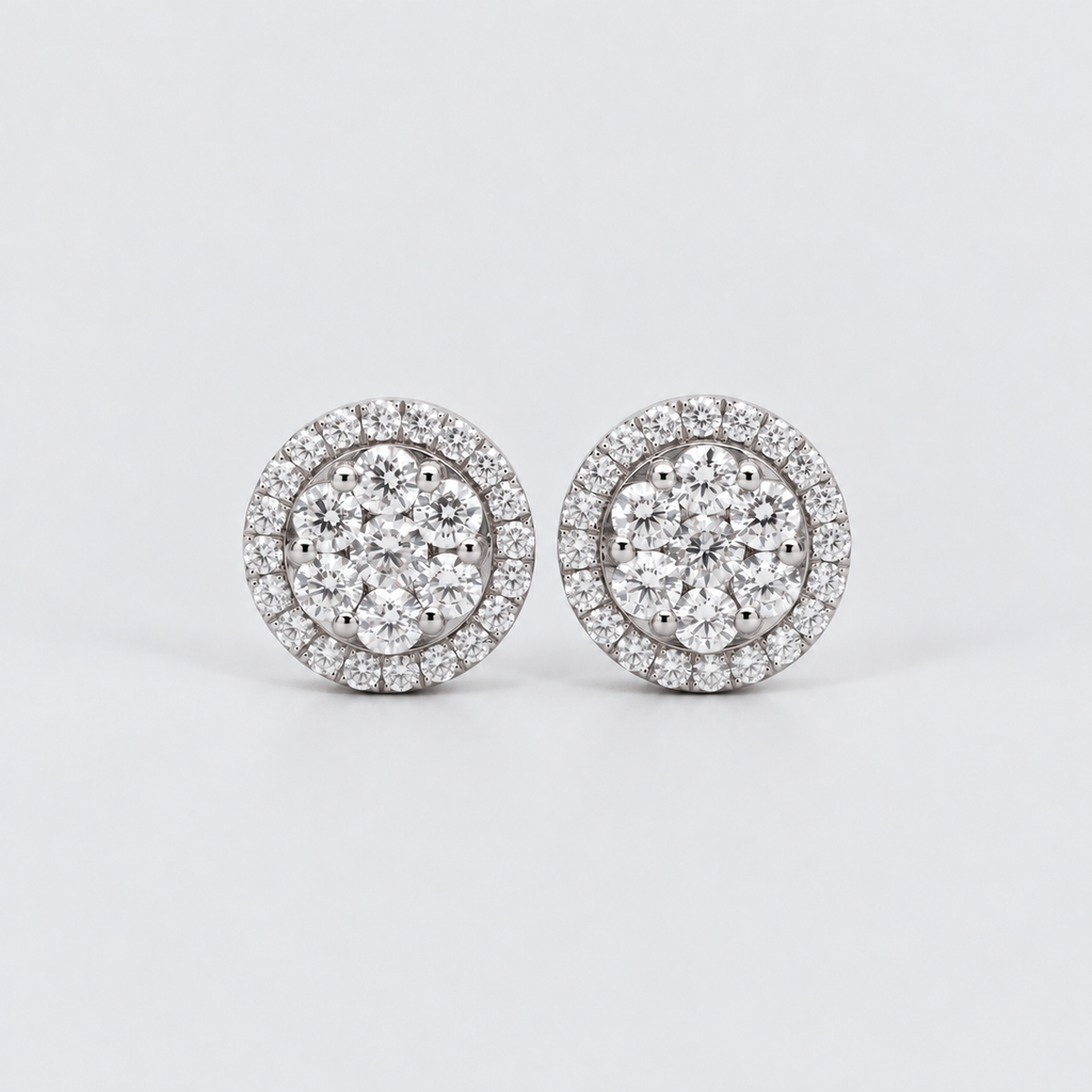 A pair of round diamond stud earrings with a double halo setting in silver-toned metal, displayed on a clean light gray background.