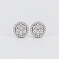 A pair of round diamond stud earrings with a double halo setting in silver-toned metal, displayed on a clean light gray background.