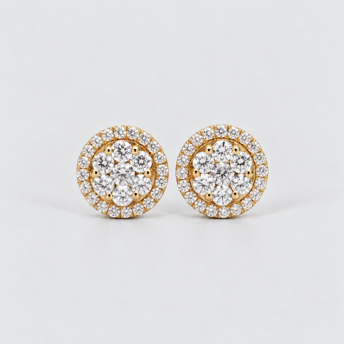 A pair of round yellow gold stud earrings set with multiple round-cut clear gemstones in a halo and cluster design, photographed on a clean light gray background.