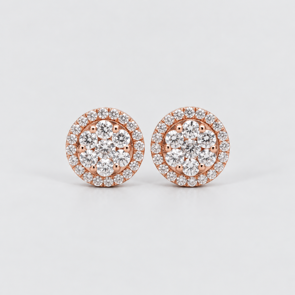 A pair of round rose gold stud earrings with multiple round-cut clear gemstones in a halo setting, displayed on a clean light gray background.