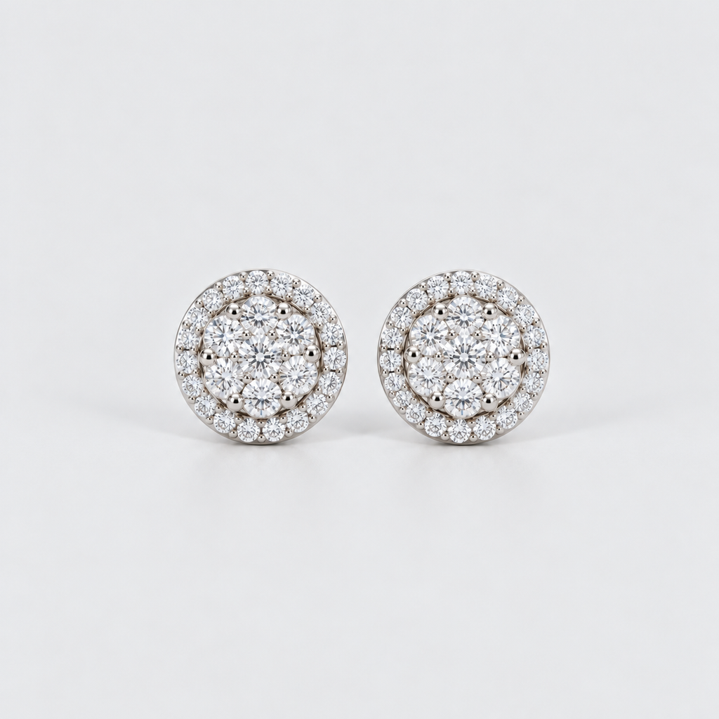 A pair of round diamond stud earrings with a double halo setting in silver-toned metal, photographed on a clean light gray background.