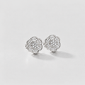 A pair of silver stud earrings with a multi-layered flower design set with small clear stones, photographed on a clean white background.
