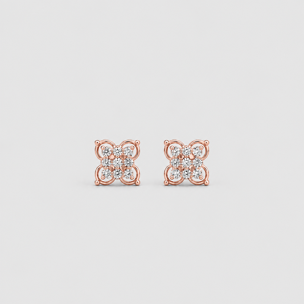 A pair of rose gold stud earrings with a square floral design set with small clear gemstones, shown on a light gray background.
