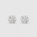 A pair of silver-toned stud earrings with intricate circular and floral designs set with clear gemstones, displayed on a light gray background.