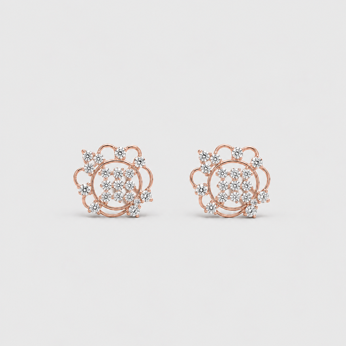 A pair of rose gold stud earrings with intricate diamond pavé and floral detailing, displayed on a clean light gray background.