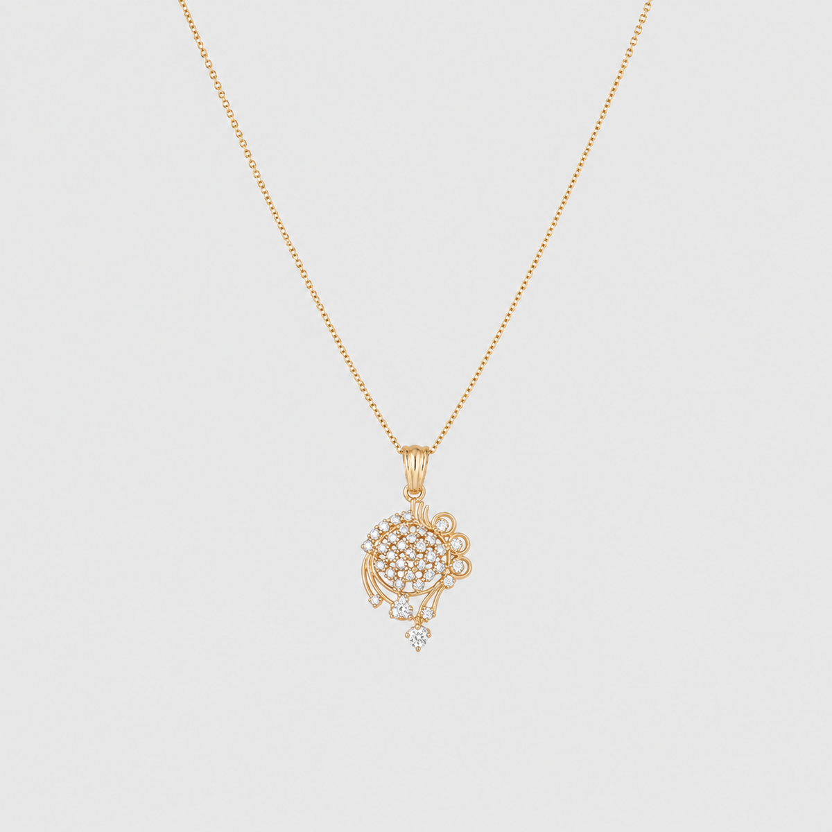 A delicate gold chain necklace with a circular pavé pendant set with small clear stones and a small dangling teardrop stone, shown on a light gray background.