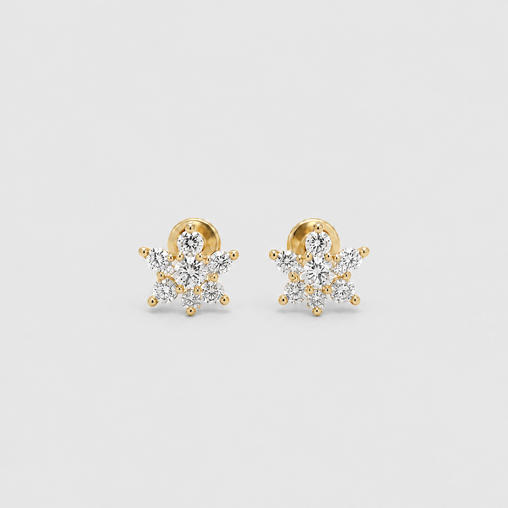 A pair of gold snowflake stud earrings set with clear gemstones, displayed on a clean light gray background.