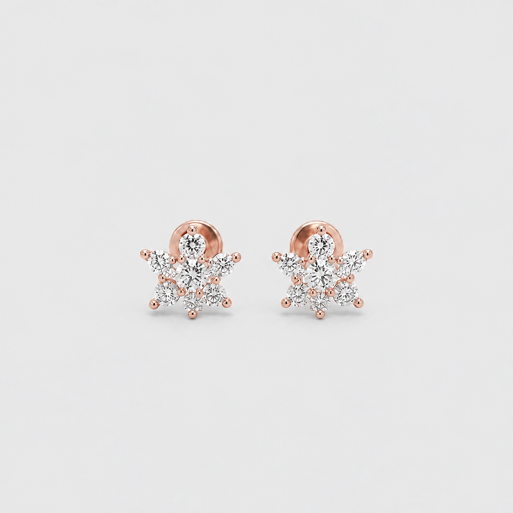 A pair of rose gold snowflake stud earrings with clear gemstones, displayed on a light gray background.