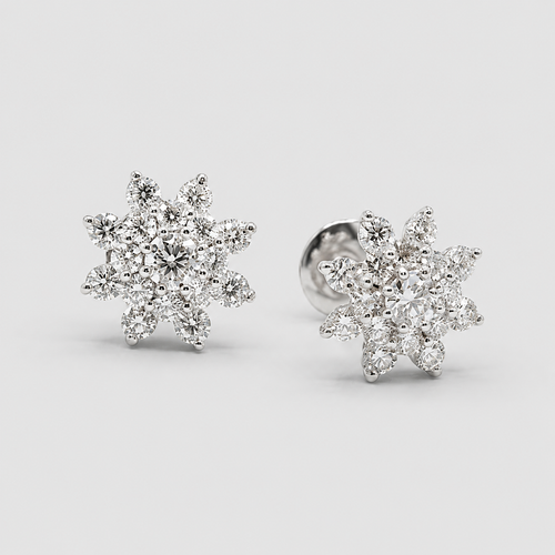 A pair of snowflake-shaped stud earrings set with clear gemstones in a silver-toned metal, shown on a light gray background.