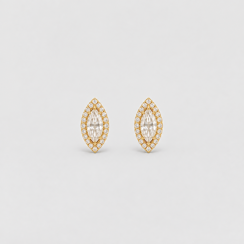 A pair of gold marquis stud earrings with marquise-cut clear gemstones surrounded by smaller round stones, set against a light gray background.
