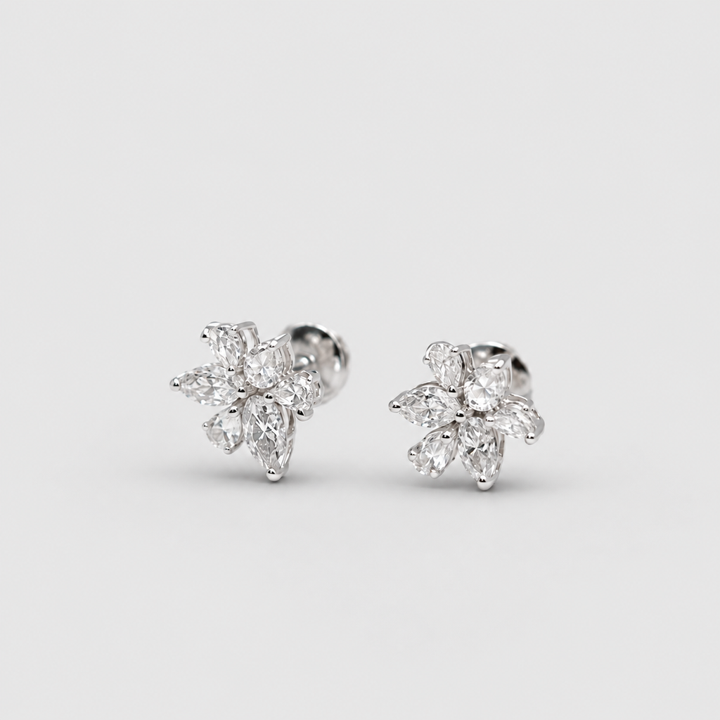 A pair of silver-toned stud earrings with marquise-cut clear gemstones arranged in a small floral or snowflake-like cluster, photographed on a clean light gray background.