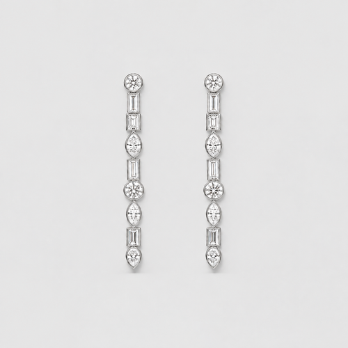A pair of silver-toned drop earrings with a vertical arrangement of clear gemstones in round, baguette, and marquise shapes, set against a plain light gray background.