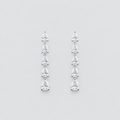A pair of silver drop earrings featuring a vertical arrangement of five pear-cut clear gemstones in a prong setting, displayed against a neutral light gray background.
