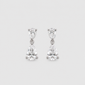 A pair of silver drop earrings featuring pear-cut clear gemstones in a three-prong setting, displayed against a light gray background.