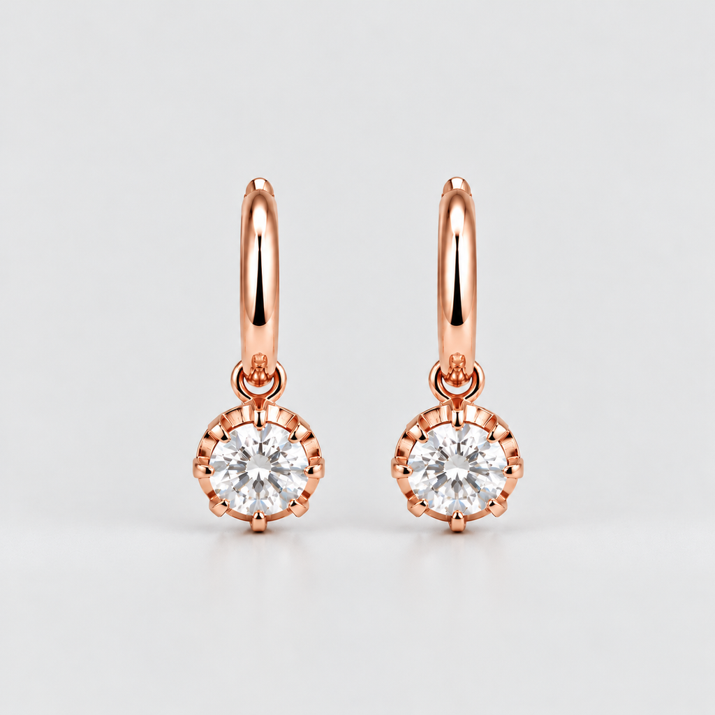 A pair of rose gold hoop earrings with round bezel-set clear gemstones, displayed on a clean light gray background.