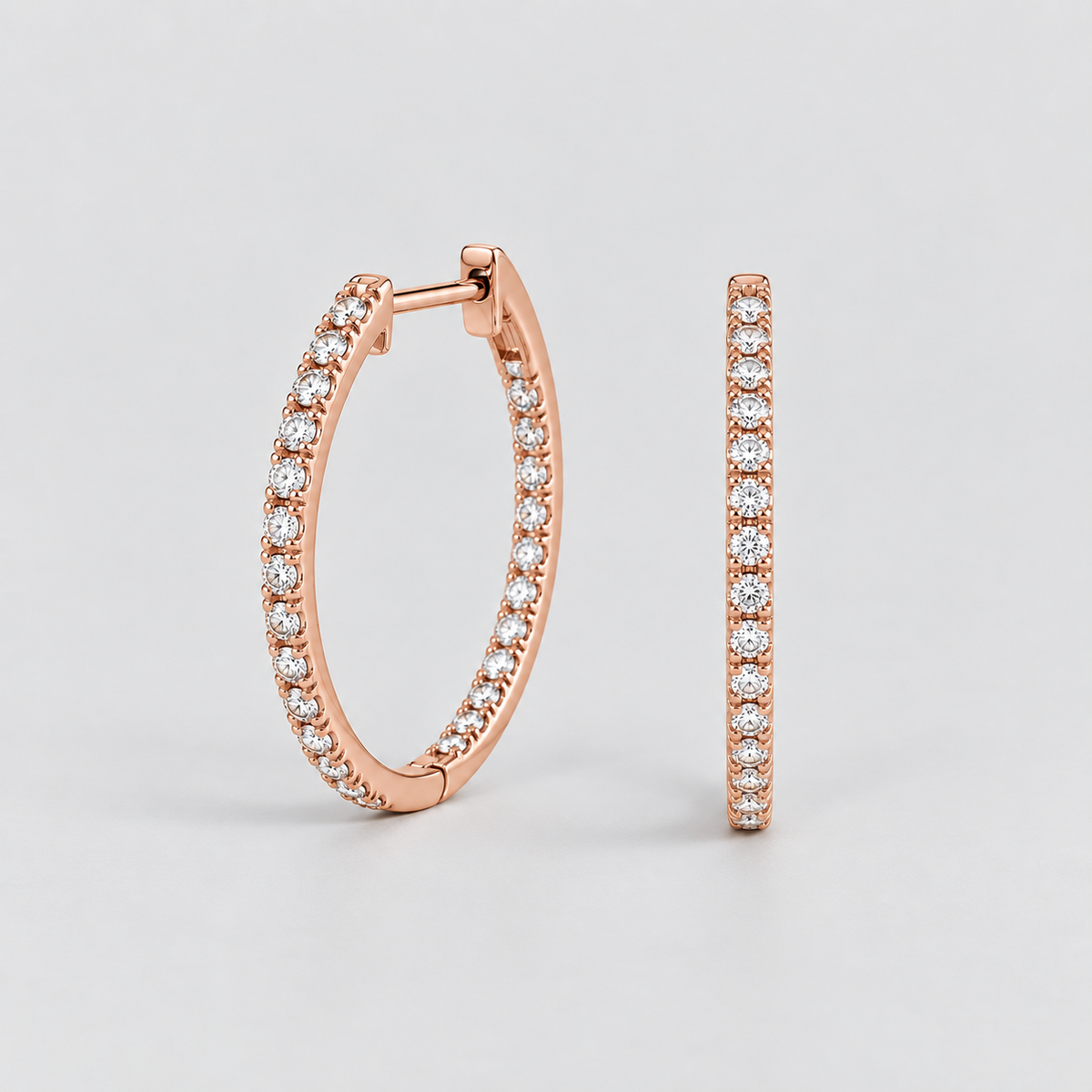 Rose gold hoop earrings with pavé-set clear stones, shown in a clean studio shot against a light gray background.