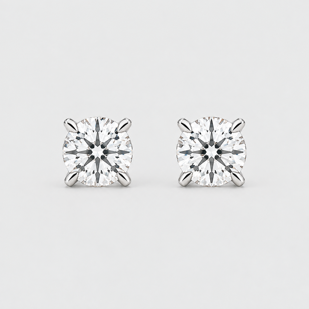 A pair of round-cut diamond stud earrings in a six-prong setting, shown on a light gray background.
